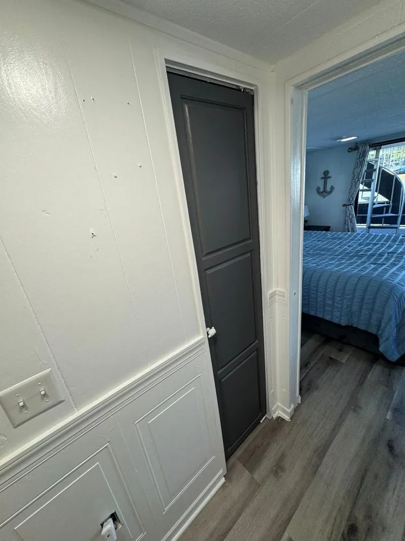 Slide: The Image of 1986 Stardust Cruisers houseboat interior with bedroom, wood flooring, and nautical decor. - 33