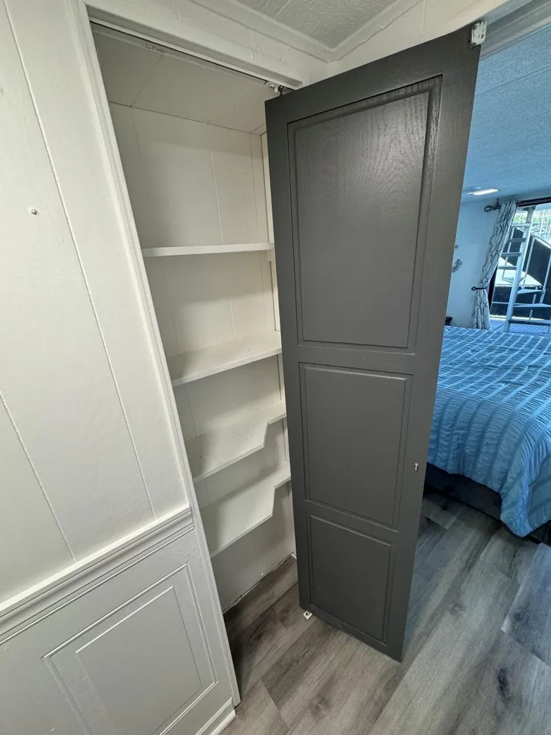 Slide: The Image of 1986 Stardust Cruisers houseboat interior with open closet and bedroom view. - 34