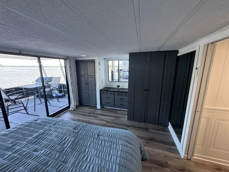 Slide: The Image of Bedroom interior of 1986 Stardust Cruisers houseboat with lake view, modern decor, and sliding glass doors. - 37