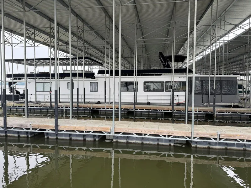 Slide: The Image of 1986 Stardust Cruisers 18 X 80 houseboat docked in a covered marina. - 4