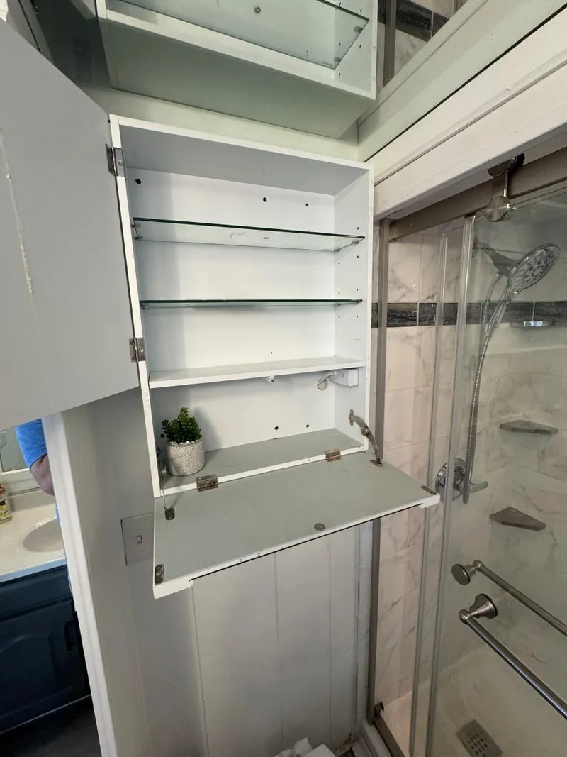 Slide: The Image of Open bathroom cabinet with glass shelves in a 1986 Stardust Cruisers houseboat. - 45