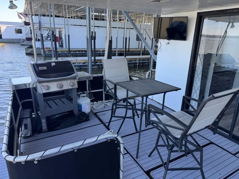 Slide: The Image of Outdoor deck of 1986 Stardust Cruisers houseboat with grill, table, and chairs. - 48