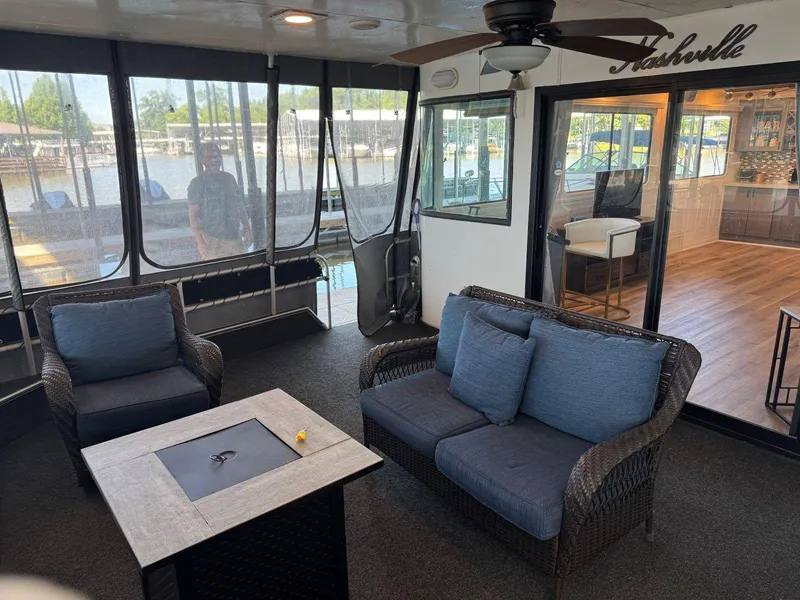 Slide: The Image of 1986 Stardust Cruisers 18 X 80 houseboat interior with seating, table, and ceiling fan. - 7