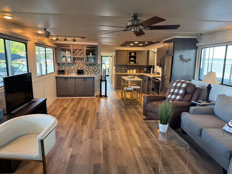 Slide: The Image of Spacious 1986 Stardust Cruisers houseboat interior with modern kitchen, cozy seating, and wood flooring. - 8