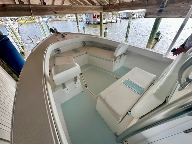Slide: The Image of 2021 Albury Brothers 27 boat interior with white seating, docked by the water. - 11