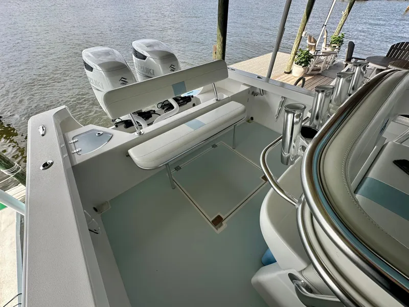 Slide: The Image of 2021 Albury Brothers 27 boat interior with dual engines and seating, docked by the water. - 13