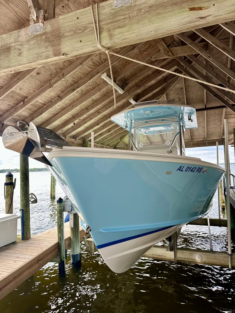Slide: The Image of 2021 Albury Brothers 27 boat docked under wooden shelter. - 2