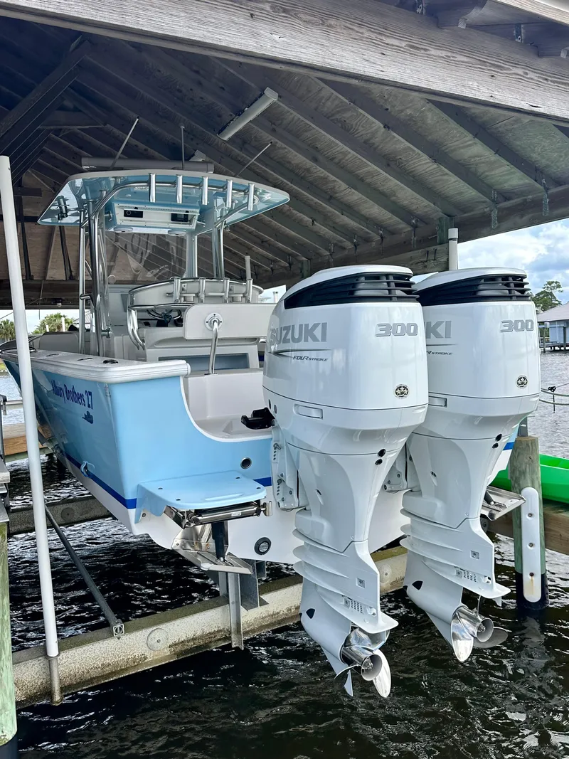 Slide: The Image of 2021 Albury Brothers 27 boat with twin Suzuki 300 engines under a wooden dock. - 5