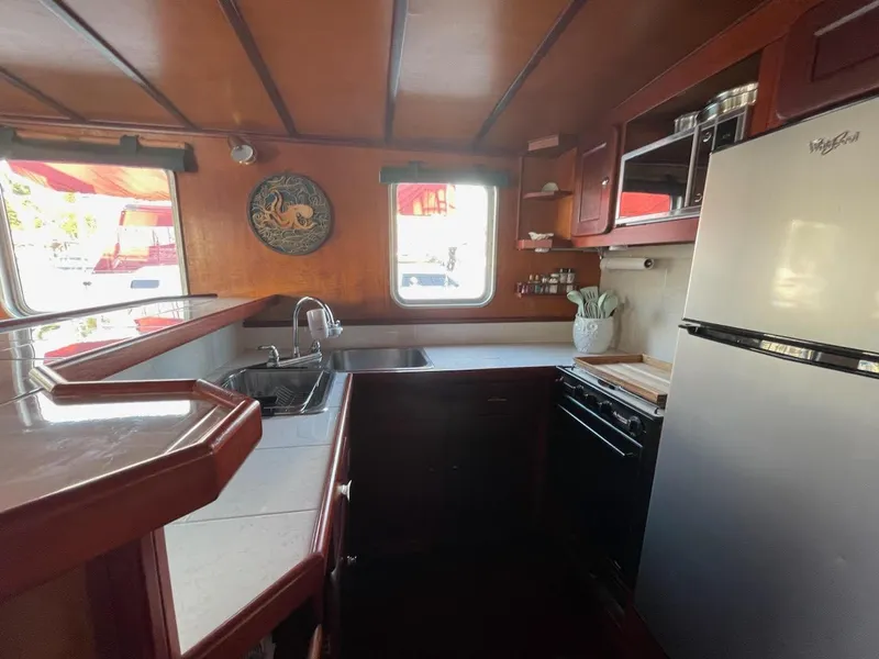 Slide: The Image of Interior of a 2010 custom trawler kitchen with wooden cabinetry and modern appliances. - 12