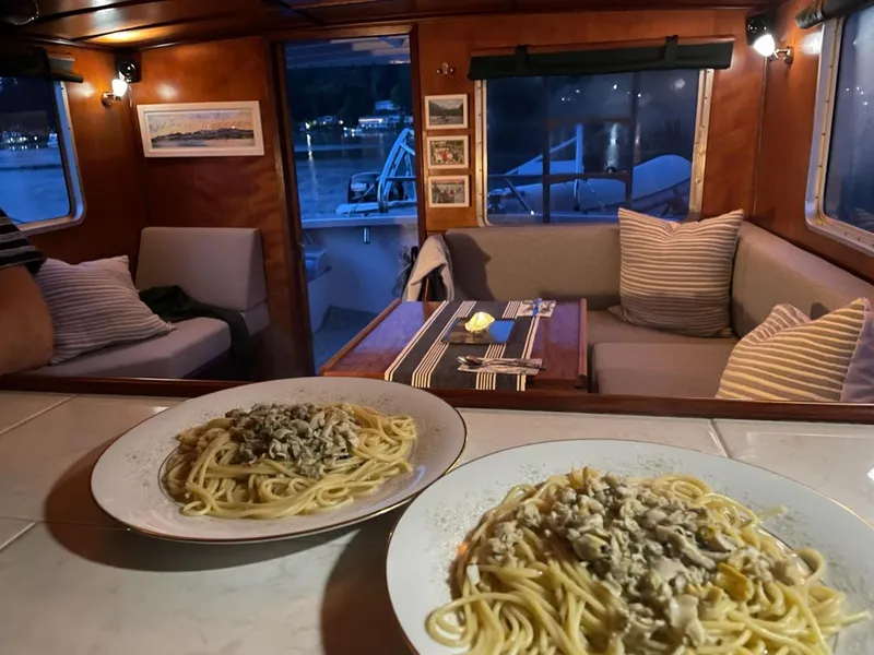 Slide: The Image of Cozy trawler interior with pasta dishes, featuring a dining area and nautical decor. - 13
