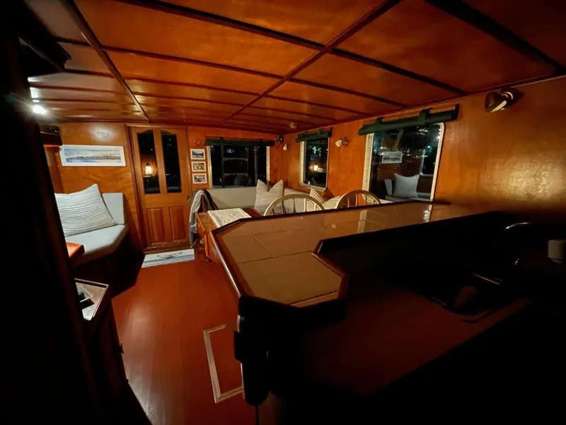 Slide: The Image of Interior of a 2010 custom trawler with warm wood paneling and cozy seating area. - 15