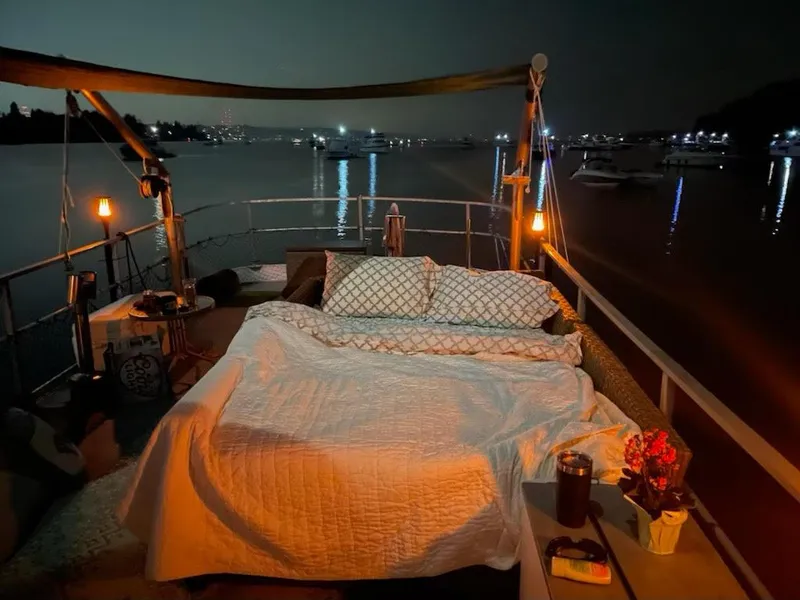 Slide: The Image of Outdoor bed setup on a 2010 Custom Trawler, overlooking a serene night harbor. - 21