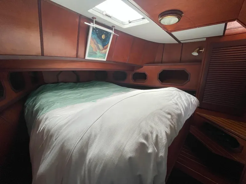 Slide: The Image of Cozy cabin interior of a 2010 custom trawler with a bed and wooden paneling. - 6