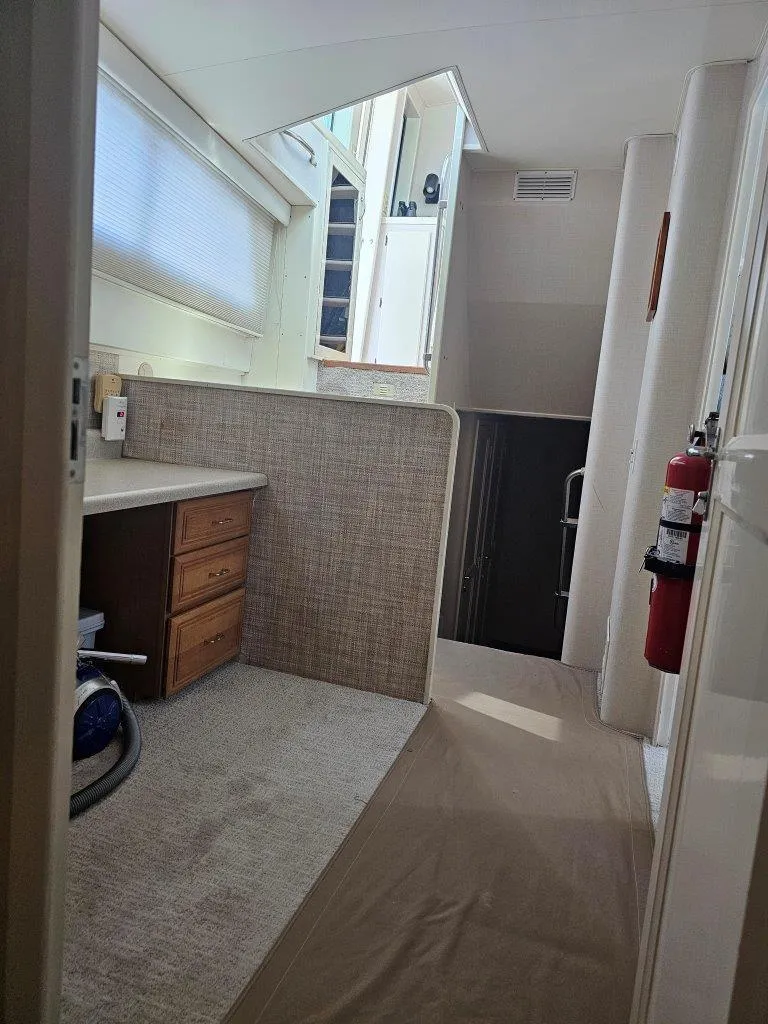 Slide: The Image of Interior of 1987 Hatteras 70 Cockpit Motor Yacht with carpeted flooring and wooden cabinetry. - 15