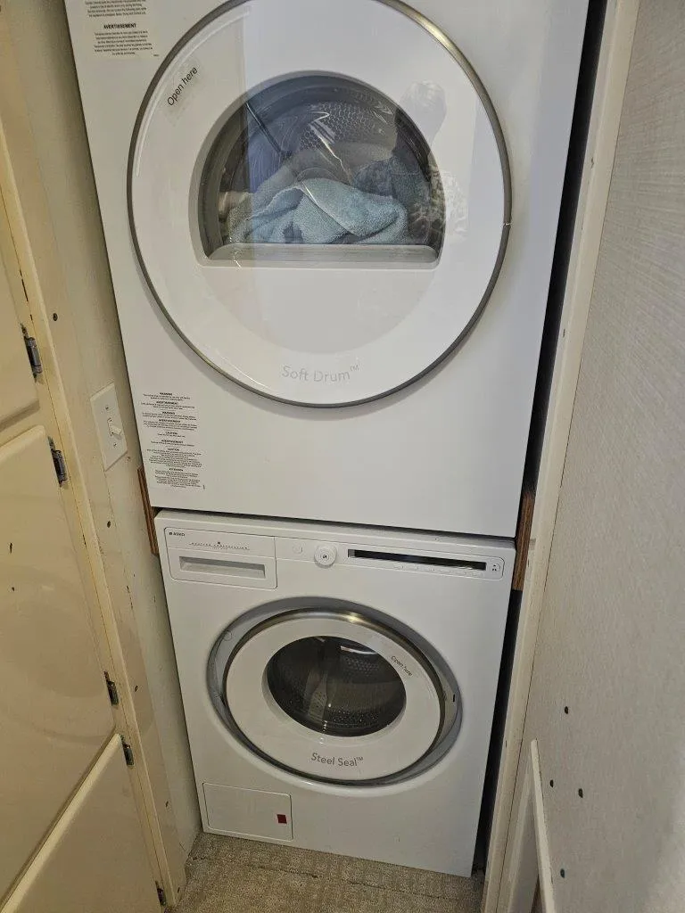 Slide: The Image of Stacked washer and dryer in a compact laundry space on a 1987 Hatteras 70 Cockpit Motor Yacht. - 16