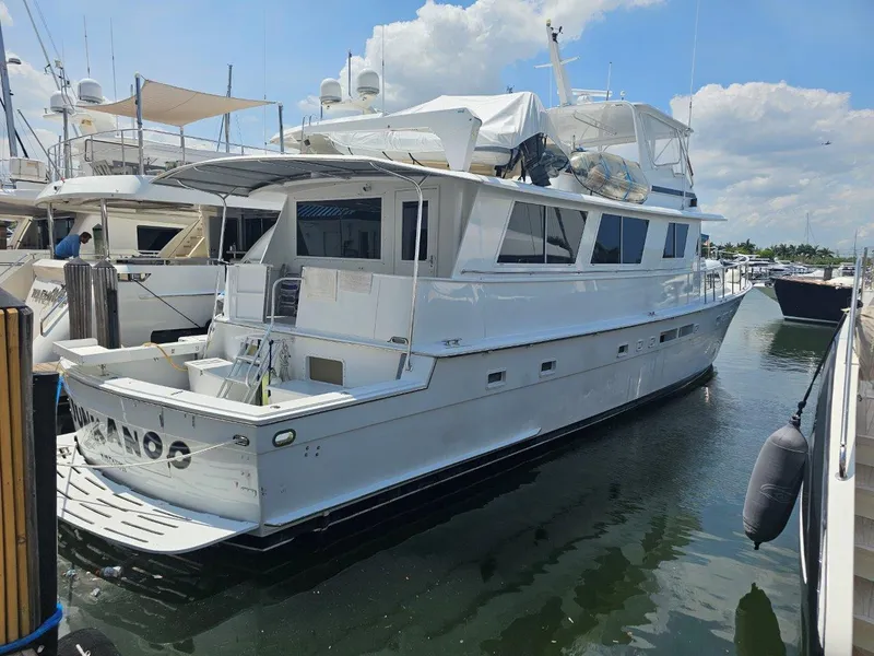 Slide: The Image of 1987 Hatteras 70 Cockpit Motor Yacht docked at marina under blue sky. - 2