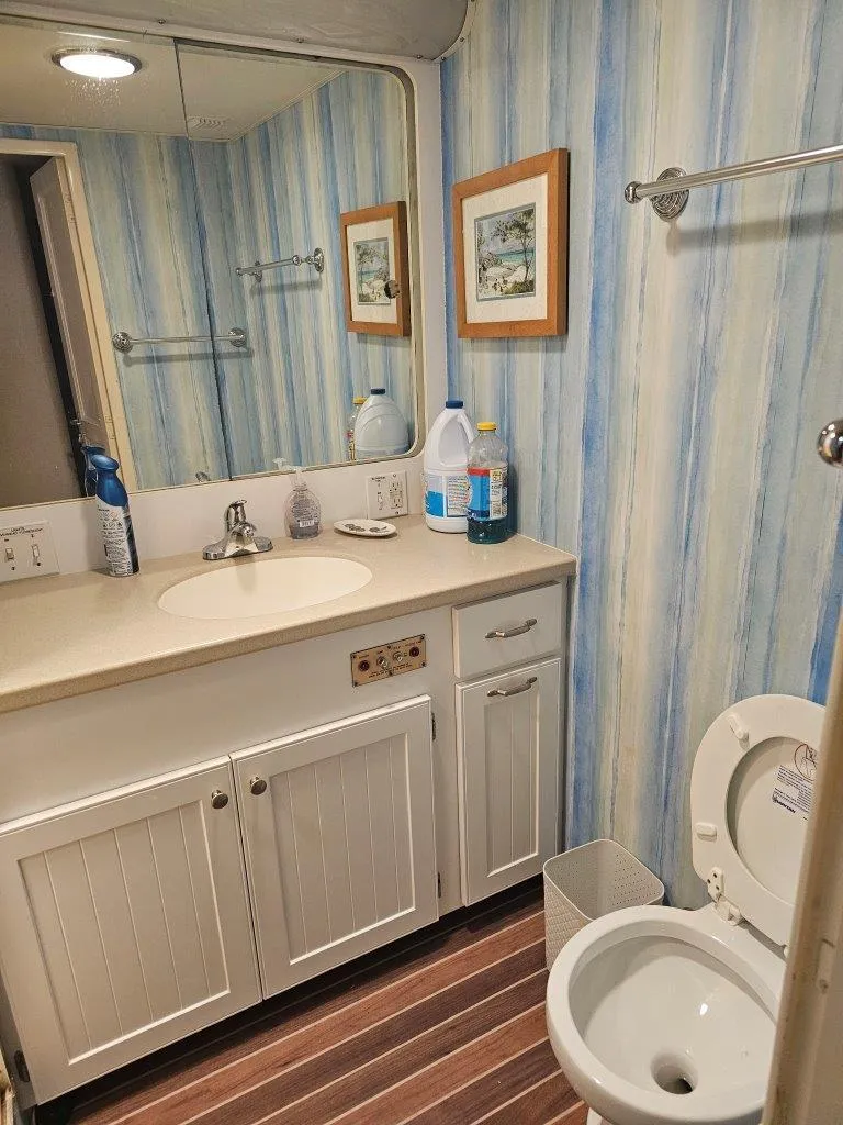 Slide: The Image of Bathroom in 1987 Hatteras 70 Cockpit Motor Yacht with striped wallpaper and wooden flooring. - 20