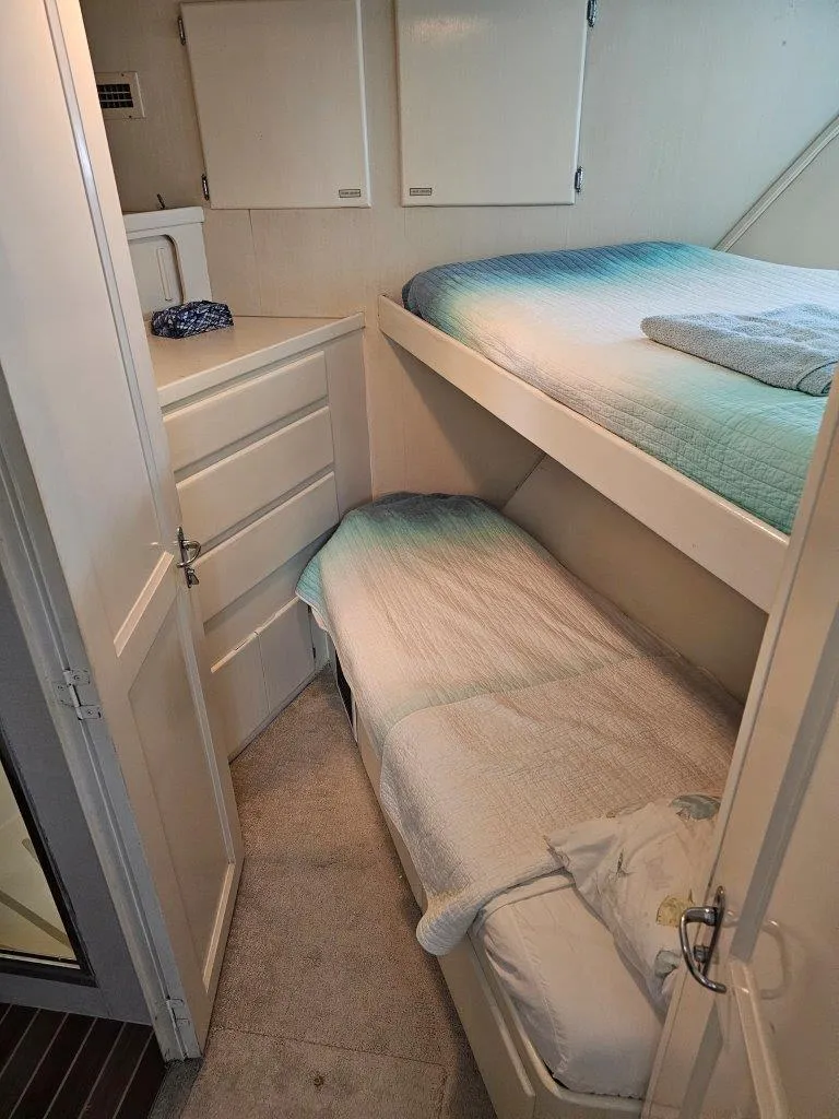 Slide: The Image of 1987 Hatteras 70 Cockpit Motor Yacht cabin with bunk beds and storage. - 21