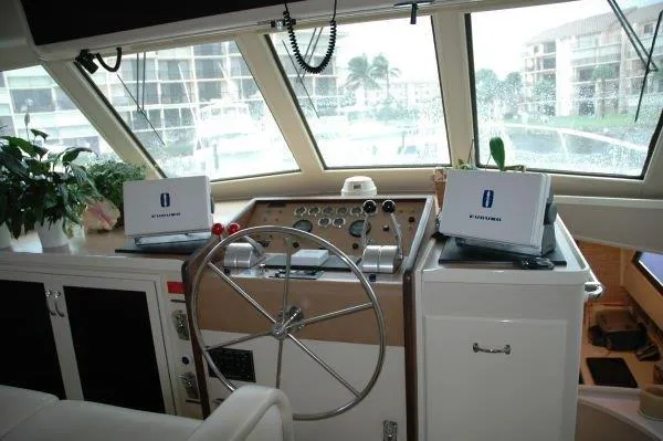 Slide: The Image of Cockpit of 1987 Hatteras 70 Cockpit Motor Yacht with steering wheel and navigation equipment. - 24