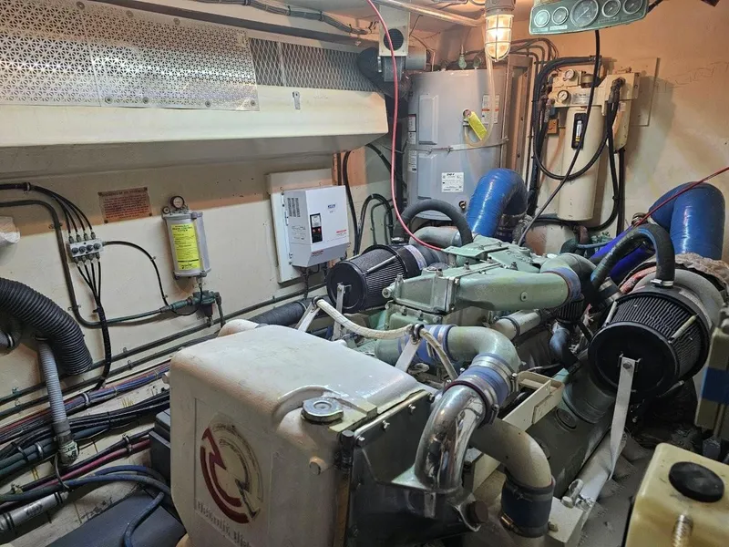 Slide: The Image of Engine room of 1987 Hatteras 70 Cockpit Motor Yacht, showcasing mechanical components and wiring. - 26