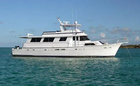 Slide: The Image of 1987 Hatteras 70 Cockpit Motor Yacht on calm blue water under clear sky. - 29