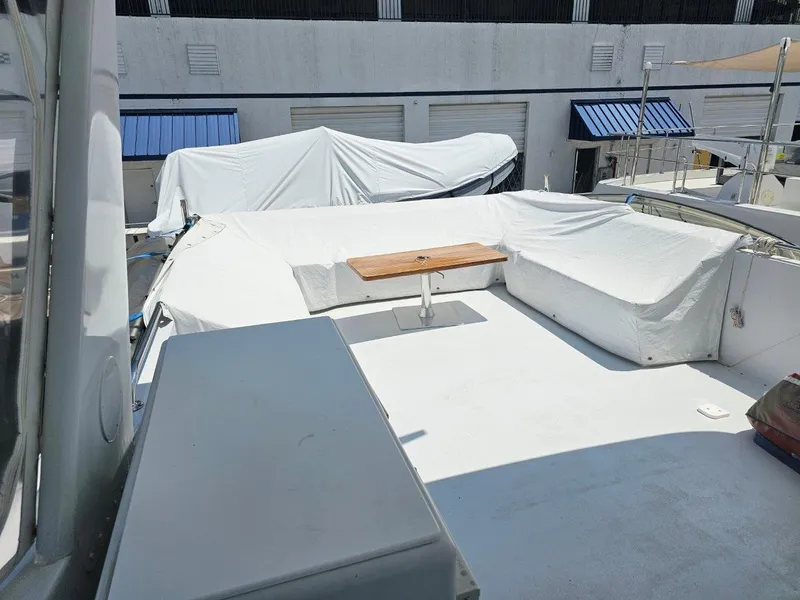 Slide: The Image of 1987 Hatteras 70 Cockpit Motor Yacht deck with covered seating and table. - 4