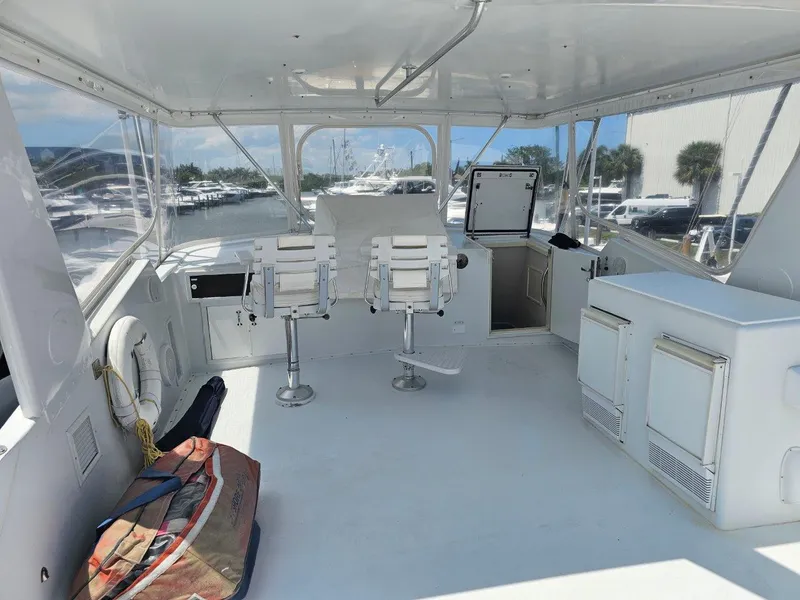Slide: The Image of 1987 Hatteras 70 Cockpit Motor Yacht interior with seating and storage, docked at marina. - 5