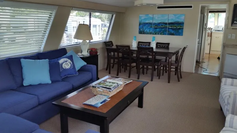 Slide: The Image of Interior of 1987 Hatteras 70 Cockpit Motor Yacht with blue sofa and dining area. - 8