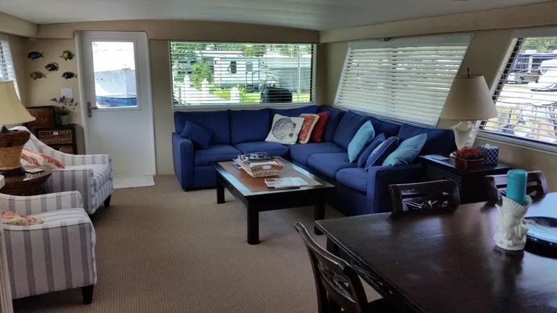 Slide: The Image of Interior of 1987 Hatteras 70 Cockpit Motor Yacht with blue sofa and dining area. - 9