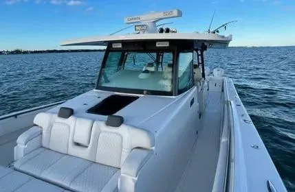 Slide: The Image of 2019 HCB 53 Sueños boat on calm water, featuring sleek design and spacious deck. - 7