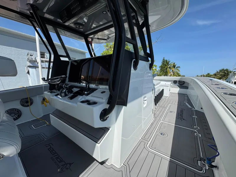 Slide: The Image of Sleek 2021 Freeman 47 boat interior with modern controls and spacious deck under clear blue sky. - 23