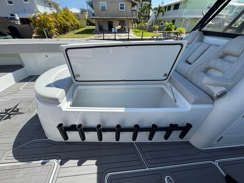 Slide: The Image of Open storage compartment on a 2021 Freeman 47 boat with rod holders and seating. - 30