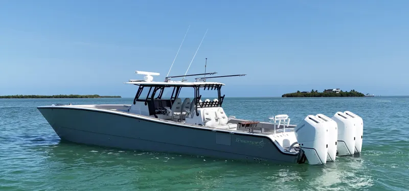 Slide: The Image of Freeman 47 boat, 2021 model, on calm water with island in background. - 4