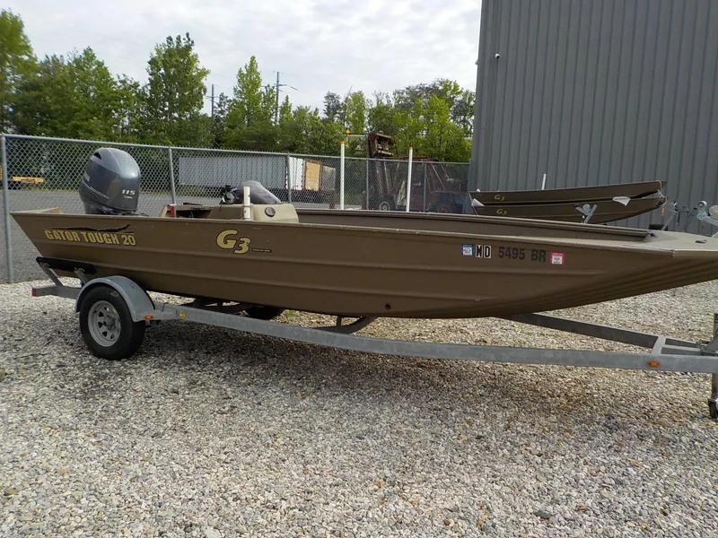 Slide: The Image of 2021 G3 20 SC boat on trailer, parked outdoors near a metal building. - 13