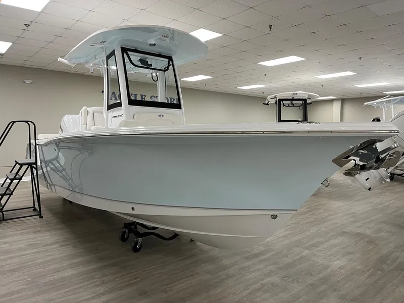 Slide: The Image of 2025 Sea Hunt Ultra 245 SE boat displayed indoors on a showroom floor. - 1