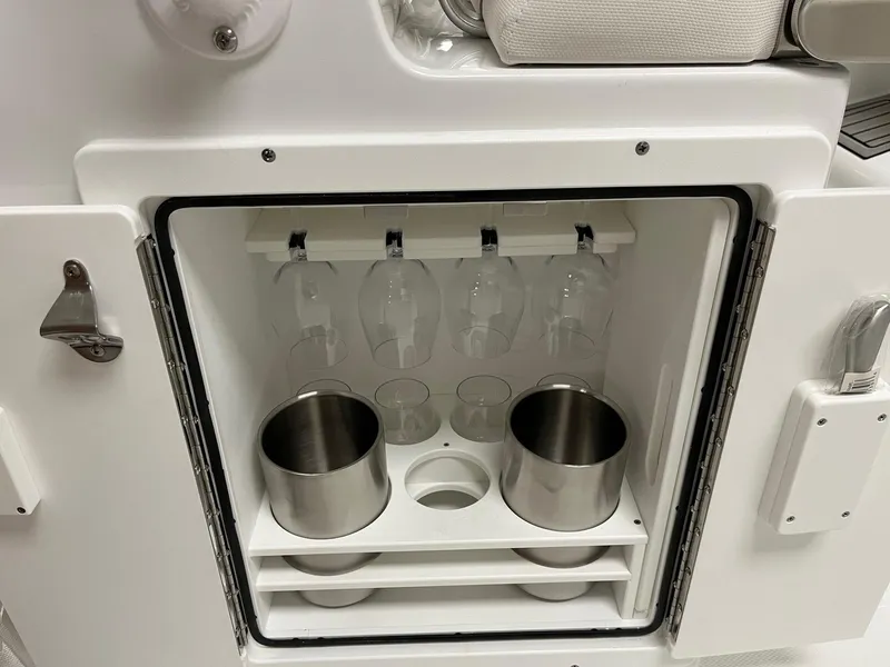 Slide: The Image of 2025 Sea Hunt Ultra 245 SE boat cabinet with glass holders and stainless steel containers. - 10