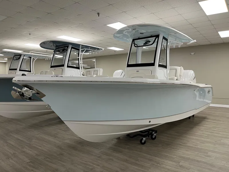 Slide: The Image of 2025 Sea Hunt Ultra 245 SE boat displayed indoors on wooden flooring. - 11