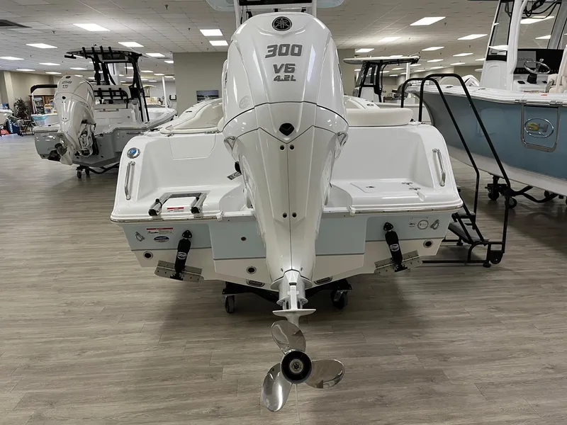 Slide: The Image of 2025 Sea Hunt Ultra 245 SE boat with powerful 300 V6 engine displayed indoors. - 12