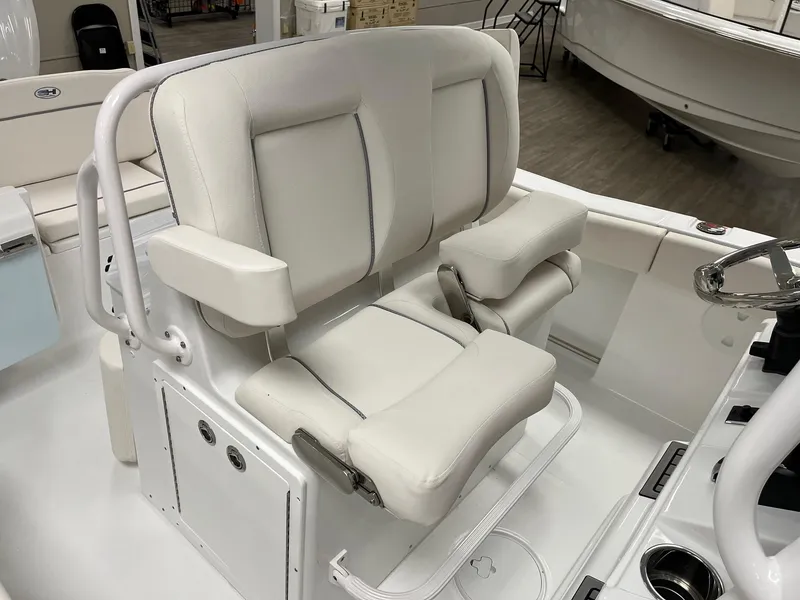 Slide: The Image of 2025 Sea Hunt Ultra 245 SE boat seat with white cushioned design and armrests. - 13