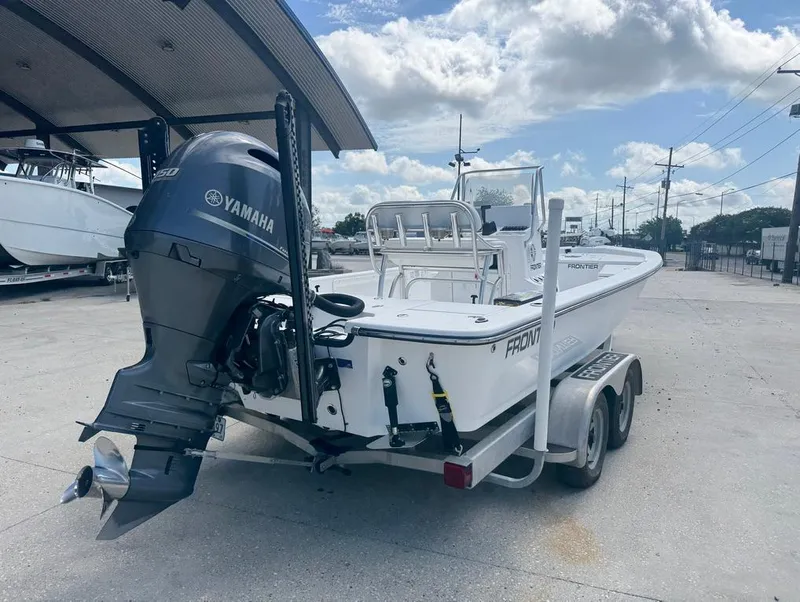 Slide: The Image of 2018 Frontier 2104 boat with Yamaha motor on trailer under blue sky. - 12