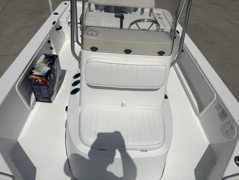Slide: The Image of 2018 Frontier 2104 boat interior with white seating and a boxed item on deck. - 16
