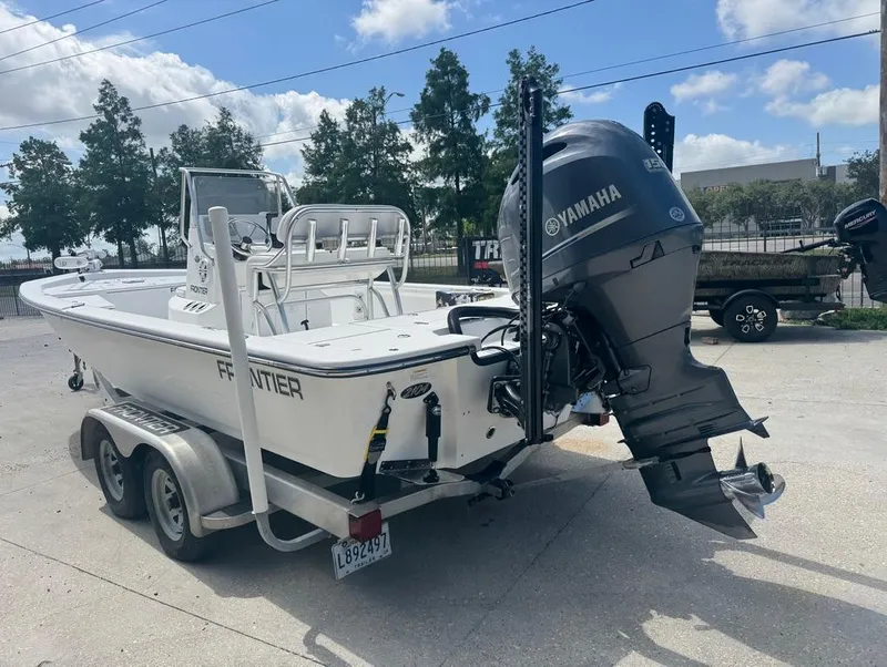 Slide: The Image of 2018 Frontier 2104 boat with Yamaha outboard motor on a trailer, parked outdoors. - 5