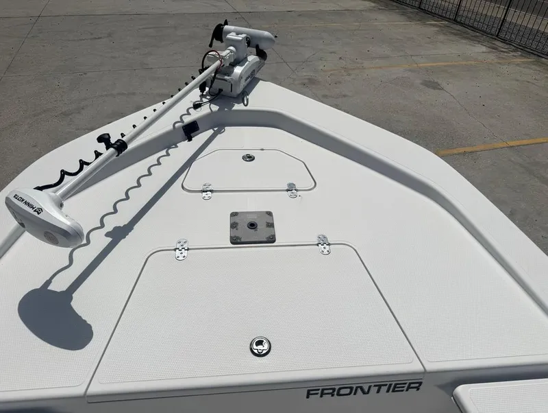 Slide: The Image of 2018 Frontier 2104 boat deck with Minn Kota trolling motor, parked on concrete. - 9