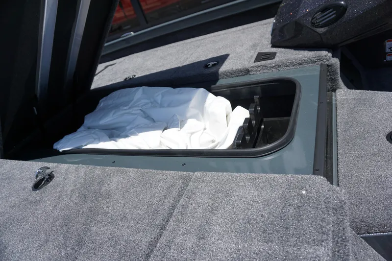 Slide: The Image of Open storage compartment in 2025 Ranger RT198P boat, featuring carpeted interior and white cover. - 18