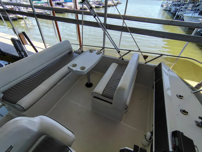 Slide: The Image of 1992 Carver Command Bridge 28 interior with seating and table, docked by the water. - 15