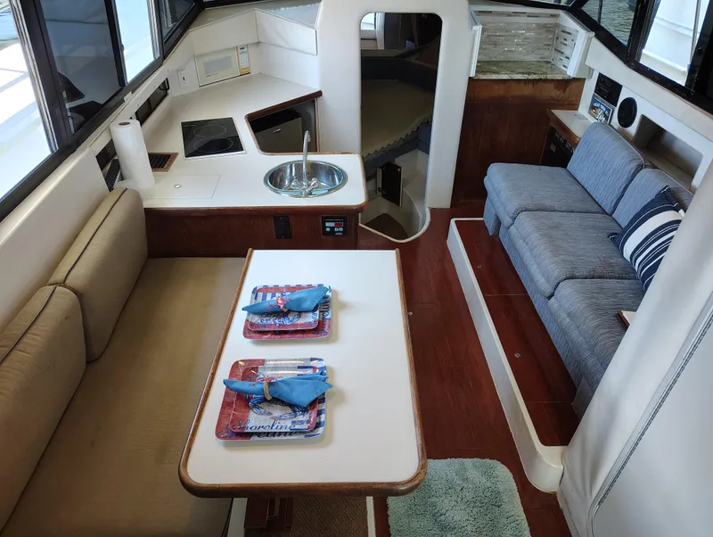 Slide: The Image of Interior of 1992 Carver Command Bridge 28 with seating, table, and kitchenette. - 16