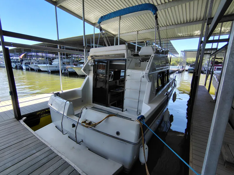Slide: The Image of 1992 Carver Command Bridge 28 docked in a marina under a covered slip. - 2