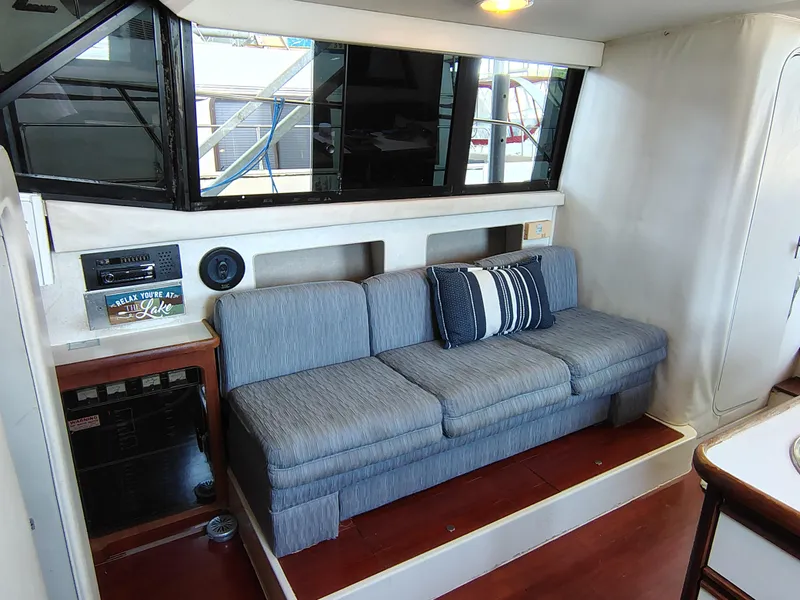 Slide: The Image of Interior of 1992 Carver Command Bridge 28 with blue sofa and striped pillows. - 20