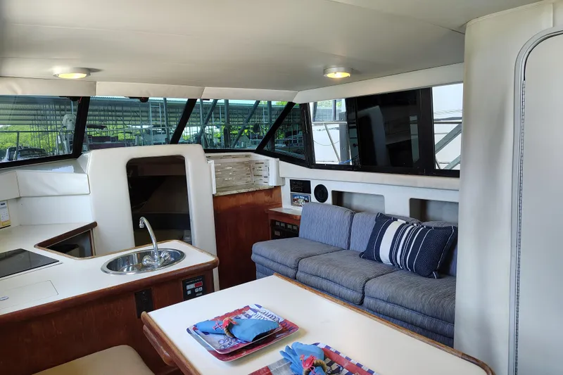 Slide: The Image of Interior of 1992 Carver Command Bridge 28 with sofa, kitchenette, and dining area. - 21