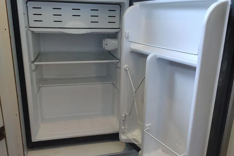 Slide: The Image of Empty refrigerator inside a 1992 Carver Command Bridge 28 boat. - 23